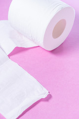 Eco-friendly white toilet paper on a pink background close-up