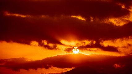 red sky and over the sunset background abstract with silhouette mountain