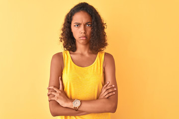 Young brazilian woman wearing t-shirt standing over isolated yellow background skeptic and nervous,...