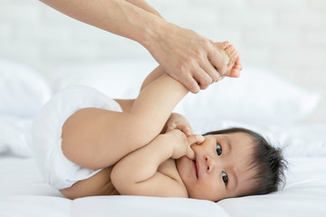Obraz na płótnie Canvas Close up mother Hands Holding Baby leg and Exercise for Healthy on bed smiling and happiness emotional in cozy bedroom,Healthy Baby Concept