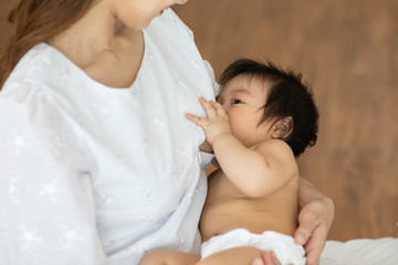 Mother holding her newborn child and breastfeeding from natural mom breast for making immunity...