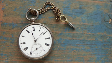 Antique pocket watch on old, weathered wooden background. Abstract time or nostalgia concept. 