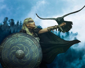 Viking blonde with war shield, sword and a black crow as a battle animal