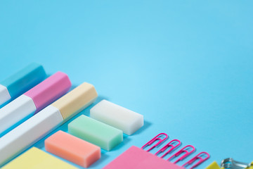Stationery, marker and paperclip on blue pastel background