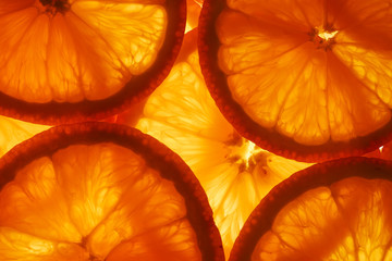 Slices of pulp and zest ripe orange with backlighting as a textural background, the substrate. Full...