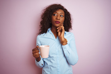 Young african american woman drinking cup of coffee over isolated pink background serious face...
