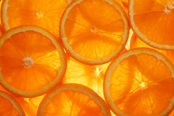 Slices of pulp and zest ripe orange with backlighting as a textural background, the substrate. Full screen, Close-up