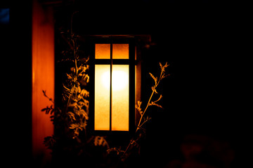 Japan in evening dark night with lantern illuminated lamp light in garden with yellow illumination color