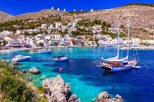 Greece Leros island aerial view of Panteli village turquoise bay with sailing boats. Traditional windmills on the hill and authentic Greek houses. Dodekanese Aegean sea 8k travel destination scenery. 