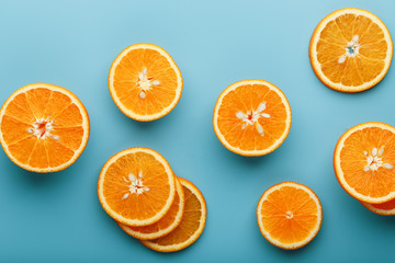 Slices and slices of orange pulp on a bright blue background as a textural background, the substrate. Full screen Flat lay, top view. Food background