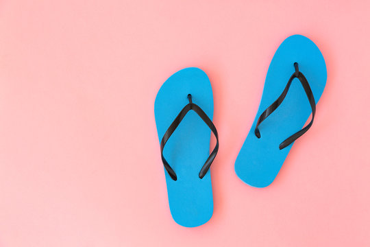 Blue flip flops on pink background. The concept of summer vacation. Top view. 