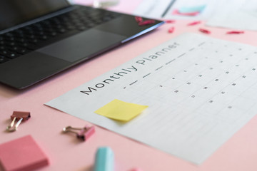 Laptop, stationery and planner on pink pastel background