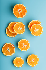 Slices and slices of orange pulp on a bright blue background as a textural background, the substrate. Full screen Flat lay, top view. Food background