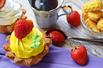 Fragrant tea and delicious cakes baskets of short pastry with jam and cream.