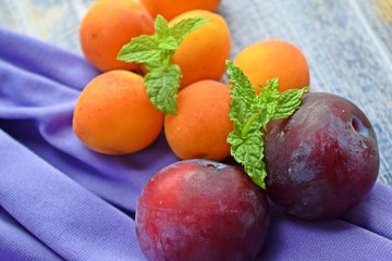 Naklejka na ściany i meble Ripe,sweet apricots and plums on wooden background.