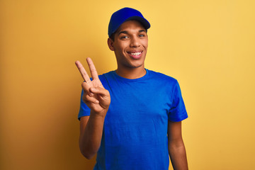Young handsome arab delivery man standing over isolated yellow background showing and pointing up...