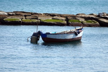 Naklejka na ściany i meble Pescatore sulla barca mentre perlustra il fondale del mare dentro uno scafandro artigianale. Sud Italia