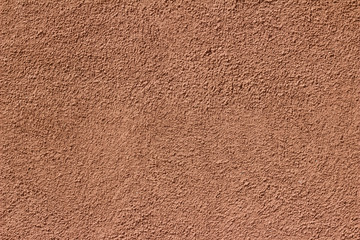 Exterior sunlit vintage red stucco wall texture background