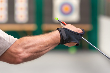 Archery. Archer exercise with the bow. Sport, recreation concept. Sportsman is preparing the arrow for the shot .