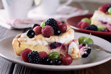 Pieces of homemade cake like cheesecake or tart with cottage cheese filling and baked icing cream and fresh berries on top, top view