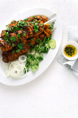Kebab roasted  on the grill on a white plate on white background top view