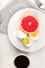 Boiled egg diet concept. Eggs with grapefruit and cup of black coffee