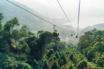 Gondola lifts moving over mountain with green trees in the area of Sun Moon Lake Ropeway in Yuchi Township, Nantou County, Taiwan. © artitwpd