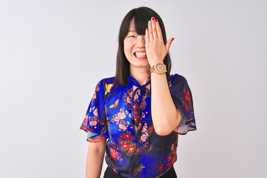 Young beautiful chinese woman wearing summer floral t-shirt over isolated white background covering one eye with hand, confident smile on face and surprise emotion.