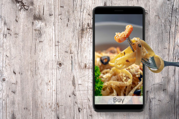 Order and food delivery from your smartphone. Smartphone on wooden background