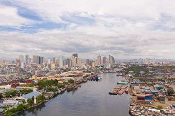 Fototapeta na wymiar The urban landscape of Manila, with slums and skyscrapers. Sea port and residential areas. The contrast of poor and rich areas. The capital of the Philippines, view from above.
