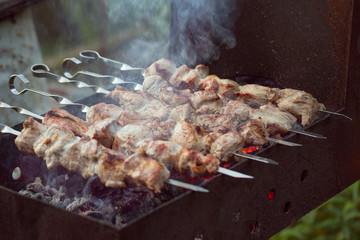 Skewers are cooked on charcoal on the grill. Pork meat on skewers.
