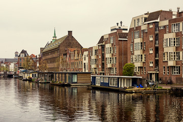 Fototapeta na wymiar Leiden, Holland, Netherlands, April 18, 2019, the old town of Leiden with historic barges and residential houses, yachts and houseboats