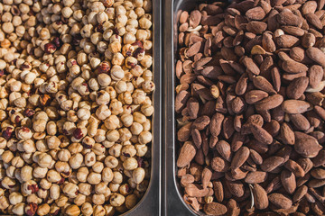 Close-up of many juicy ripe hazelnuts and almonds on the counter - traditional Mediterranean market - selected top-quality organic products