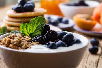 Morning meal, homemade granola with yogurt, fresh summer berries, fruits