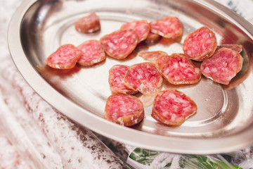 Slices of ham and smoked sausage for tasting in the butcher shop - traditional Mediterranean market - selected top-quality natural products