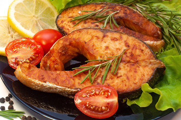 Grilled Salmon Steaks on a Plate with Lemon and Tomato