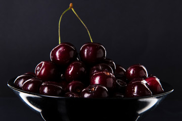 cherry in a black plate on a dark background