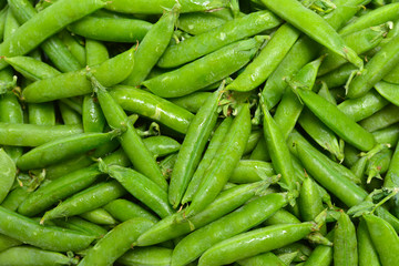 Fresh pea pods as background. Top view.