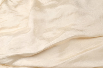 Soft smooth beige silk fabric background. Fabric texture.