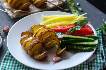 Homemade Tornado spiral baked potato with vegetable salad. Tomatoes cucumber pepper