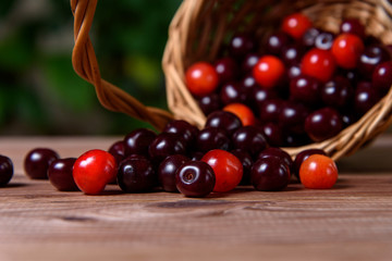 Cherry in a wooden wicker basket on a wooden table.