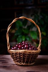 Fototapeta na wymiar Cherry in a wooden wicker basket on a wooden table.