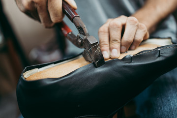 Close up shot of old shoemaker shearing the edges of the leather. Traditional way of shoe making...