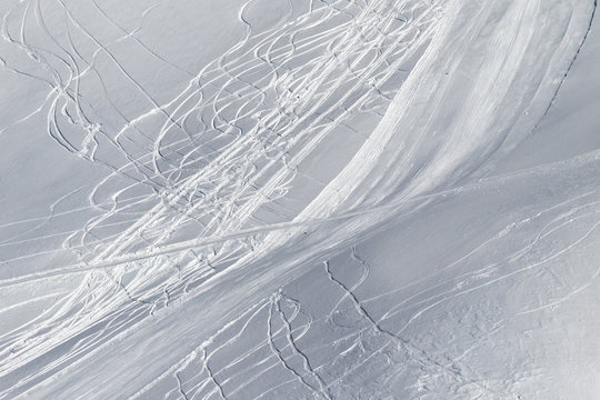 Snowy off piste slope with traces of skis and snowboards