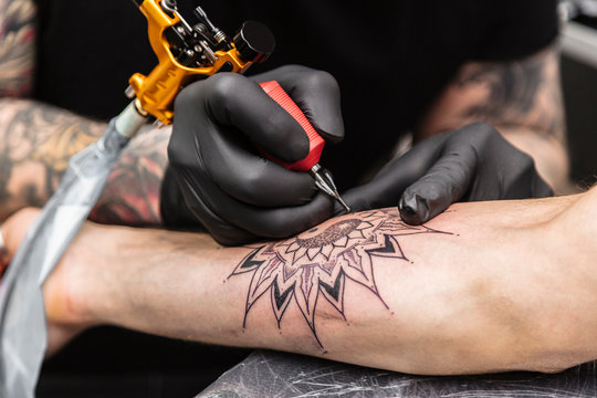 Process of creating tattoo in form of black flower