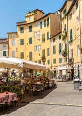 Amphitheater square with restaurants, bars and tourists in old town Lucca, Tuscany, Italy - obrazy, fototapety, plakaty