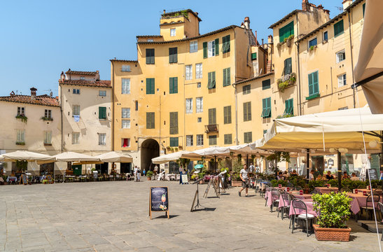 Amphitheater square with restaurants, bars and tourists in old town Lucca, Tuscany, Italy