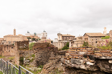 Fototapeta premium buildings and ruined bricked walls under grey sky in rome, italy