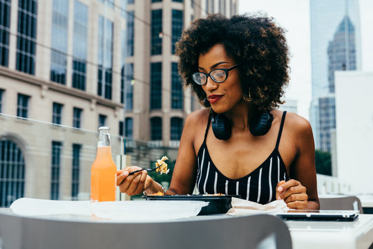 Woman with eyeglasses eating lunch outdoors