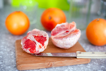 Grapefruits and knife on cutting board